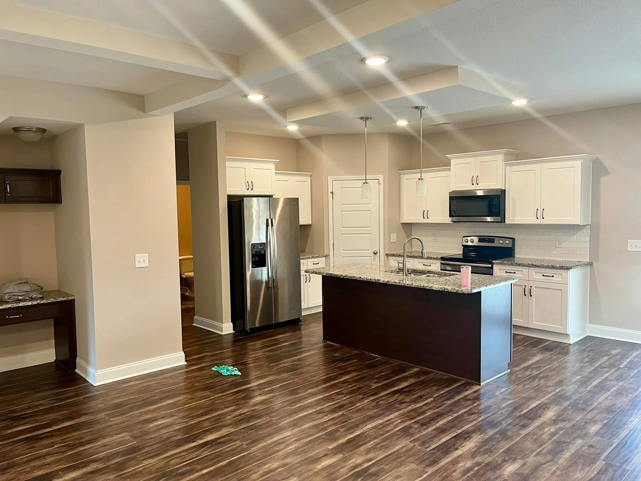 White painted kitchen cabinets, neutral walls, and white coffered ceiling with recessed lighting
